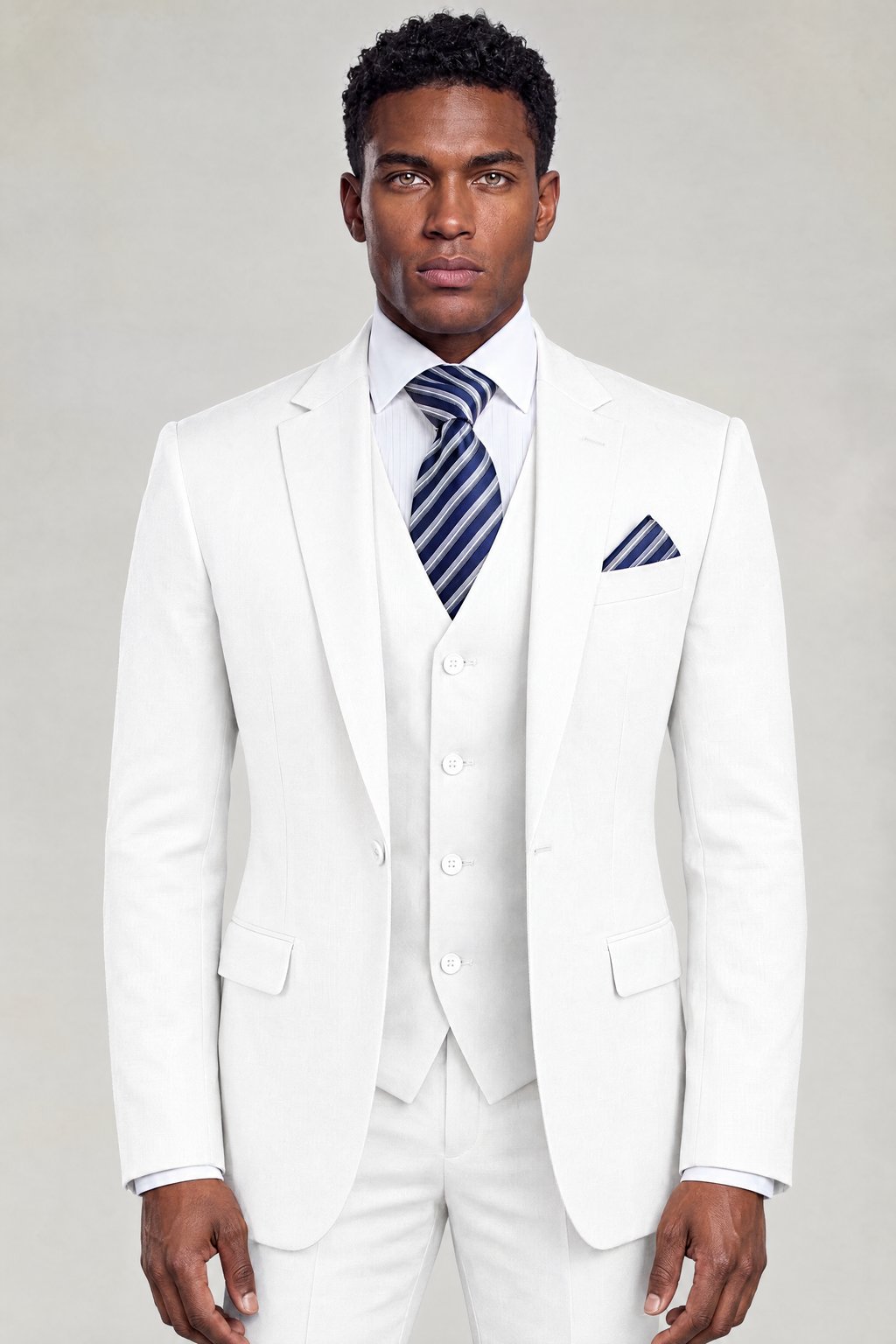 Front portrait of a classic white three-piece suit with notch lapels and a striped navy tie from Gentleman's Guru