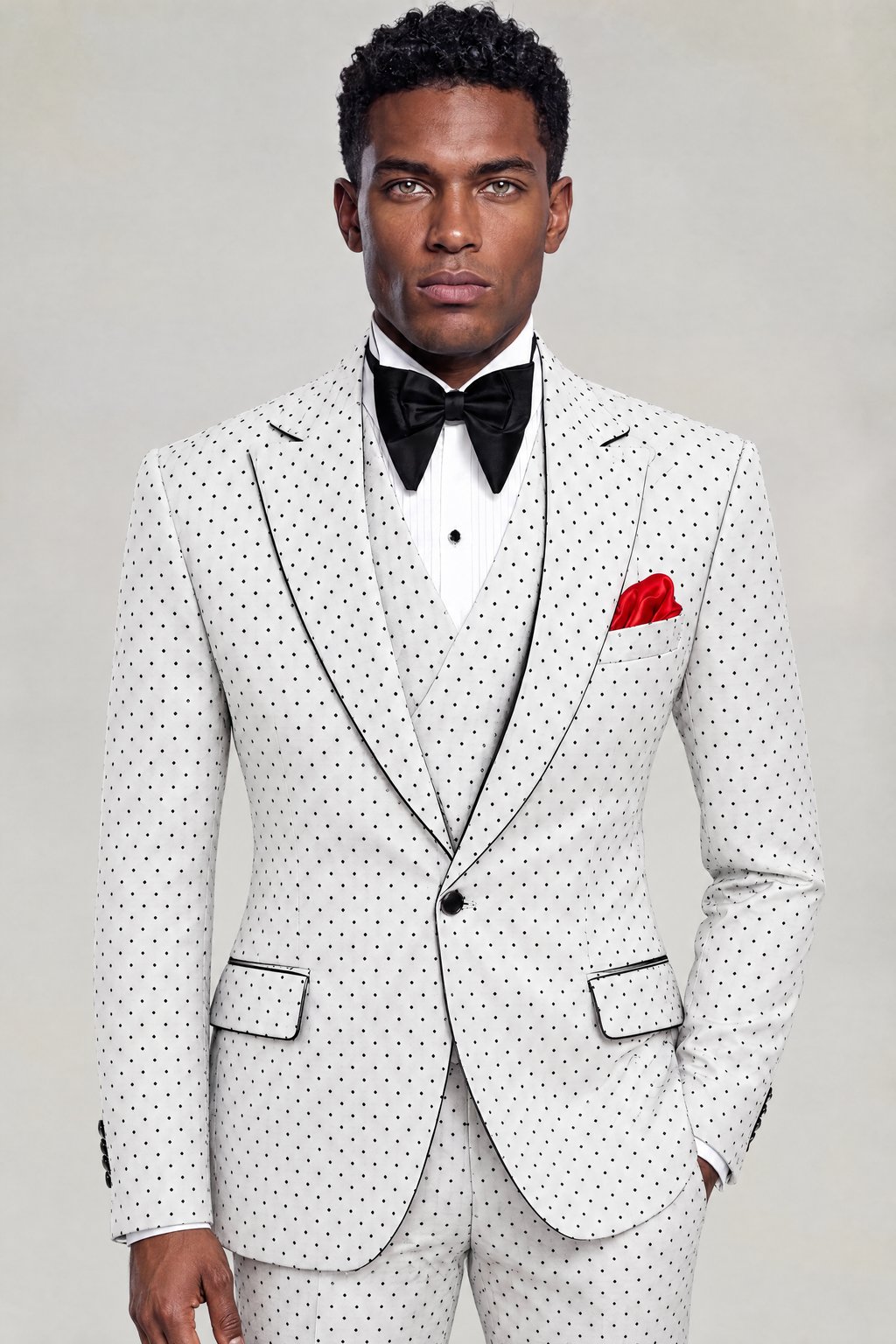 Front portrait of a white polka dot three-piece suit with black piping and a red pocket square from Gentleman's Guru