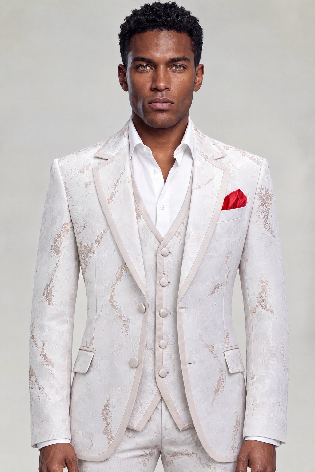 Front portrait of an ivory and rose gold abstract-print tuxedo with matching vest and open-collar white shirt from Gentleman's Guru